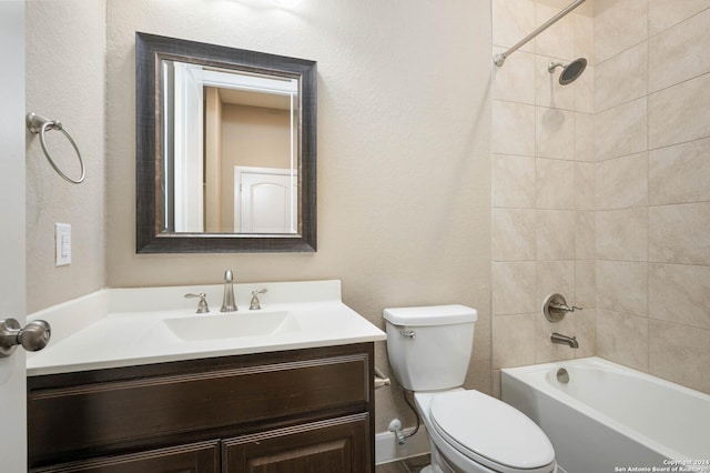 full bathroom featuring vanity, tiled shower / bath combo, and toilet