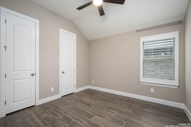 unfurnished bedroom with ceiling fan, dark wood-type flooring, and lofted ceiling