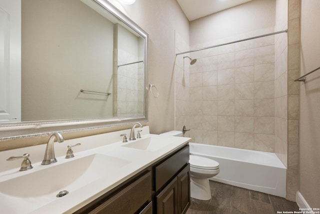 full bathroom featuring toilet, vanity, wood-type flooring, and tiled shower / bath