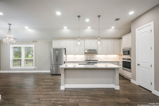 kitchen with light stone countertops, stainless steel appliances, a kitchen island with sink, white cabinets, and dark hardwood / wood-style floors