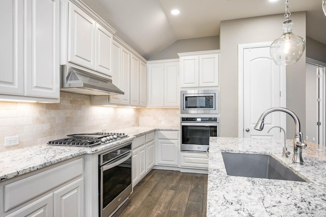 kitchen with white cabinetry, sink, pendant lighting, decorative backsplash, and appliances with stainless steel finishes