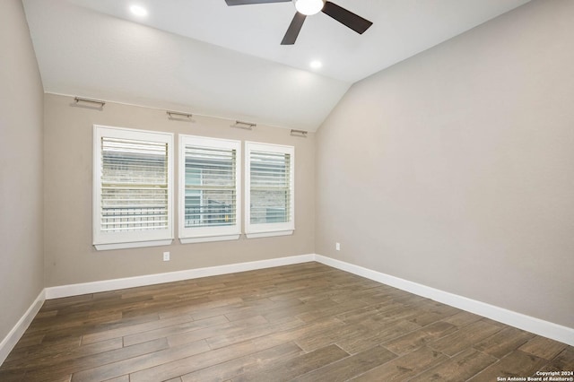 spare room featuring dark hardwood / wood-style floors, ceiling fan, and vaulted ceiling