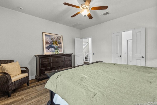 bedroom with dark hardwood / wood-style floors and ceiling fan