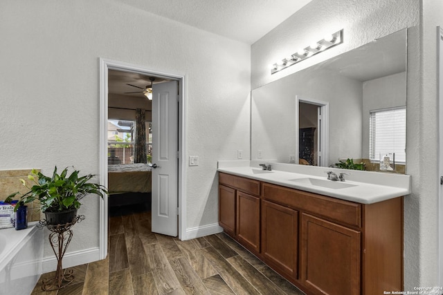 bathroom featuring hardwood / wood-style floors, ceiling fan, a textured ceiling, and vanity