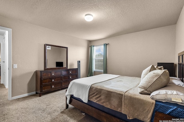 bedroom featuring light colored carpet and a textured ceiling