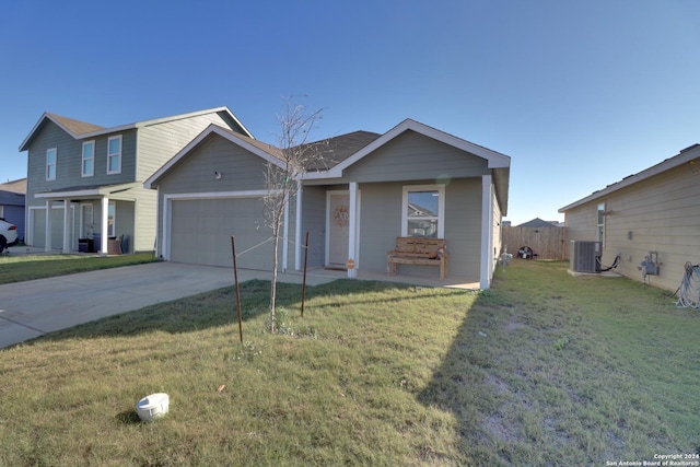 view of front of home featuring central air condition unit, a front lawn, and a garage