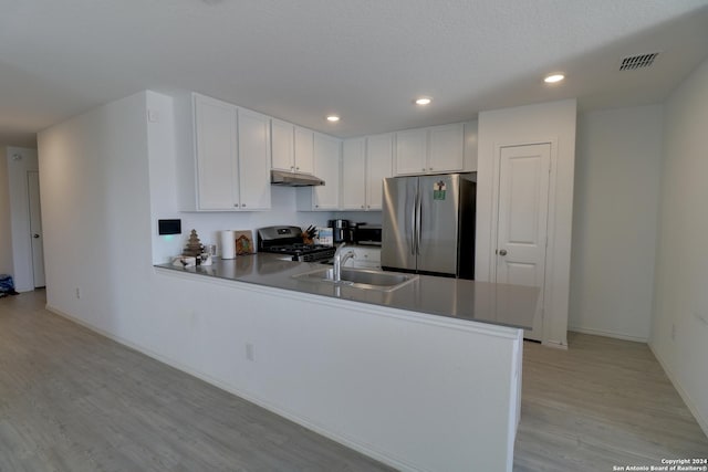 kitchen with kitchen peninsula, stainless steel appliances, sink, light hardwood / wood-style floors, and white cabinetry