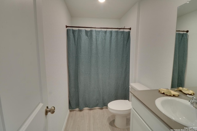 bathroom with hardwood / wood-style floors, vanity, and toilet