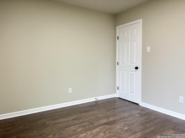 unfurnished room featuring dark wood-type flooring