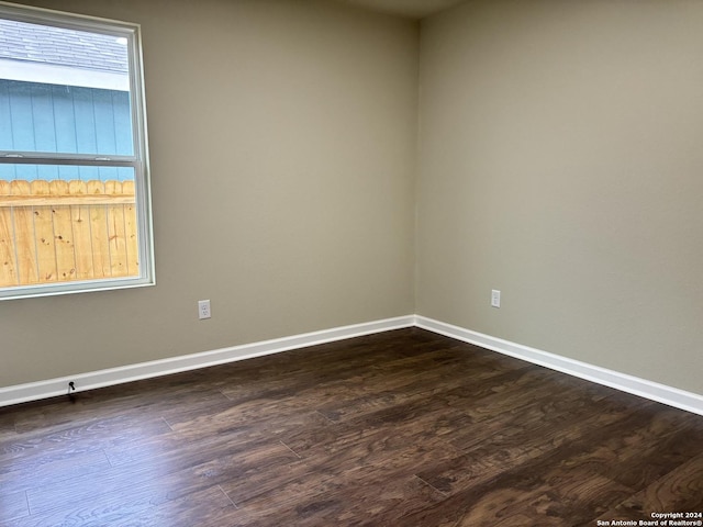 unfurnished room with dark wood-type flooring