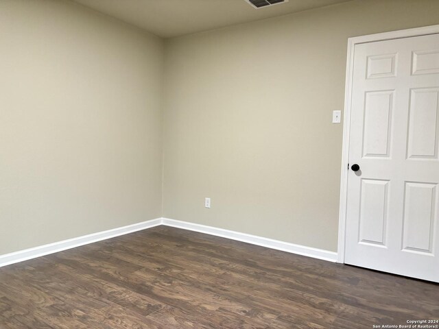 empty room with dark hardwood / wood-style flooring