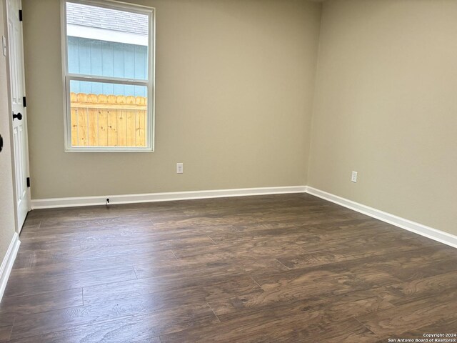 unfurnished room featuring dark wood-type flooring