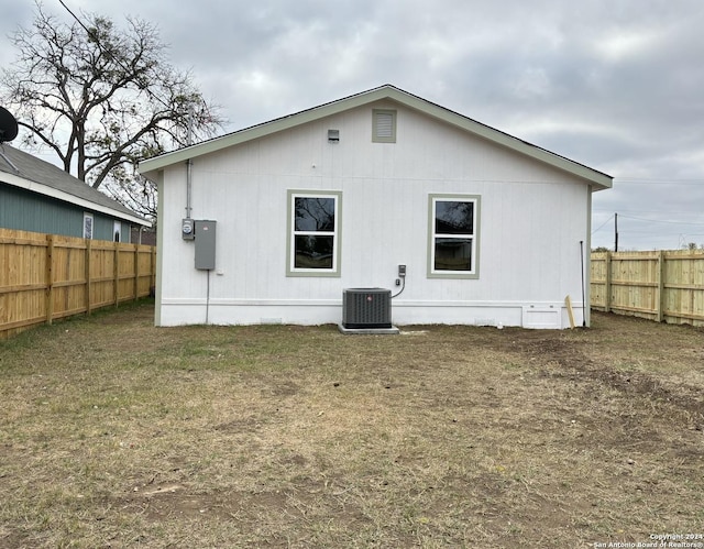 rear view of property with a yard and central AC