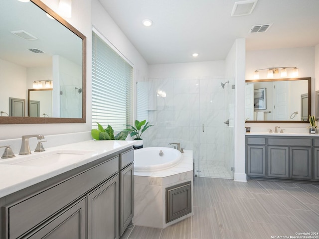 bathroom with vanity and shower with separate bathtub