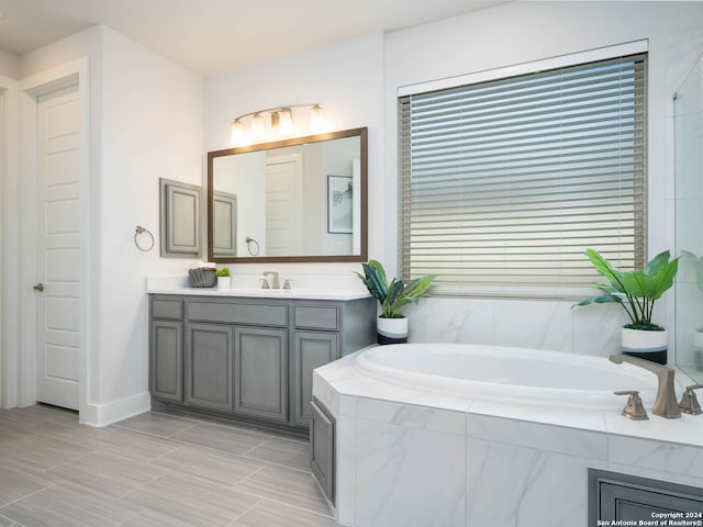 bathroom featuring vanity and a relaxing tiled tub