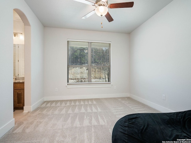 carpeted bedroom with connected bathroom and ceiling fan