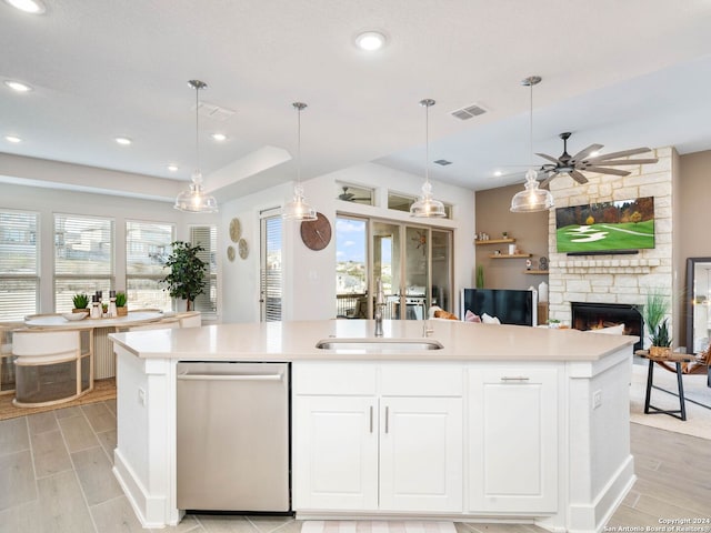 kitchen featuring dishwasher, a healthy amount of sunlight, and a kitchen island with sink