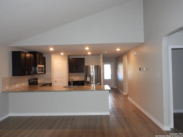 kitchen featuring sink, stainless steel appliances, light stone counters, dark hardwood / wood-style floors, and kitchen peninsula