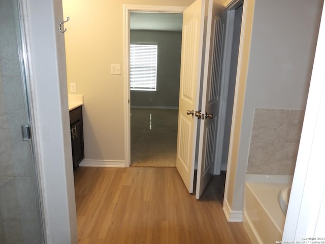 bathroom with wood-type flooring, vanity, and separate shower and tub