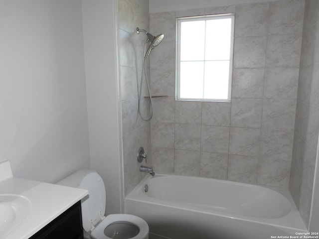 full bathroom featuring toilet, tiled shower / bath, and a wealth of natural light