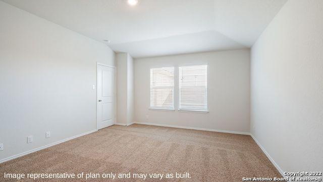 carpeted empty room featuring lofted ceiling