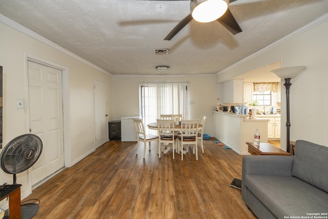 dining space featuring a textured ceiling, dark hardwood / wood-style floors, ceiling fan, and crown molding