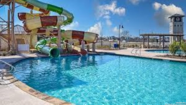 view of swimming pool with a water slide