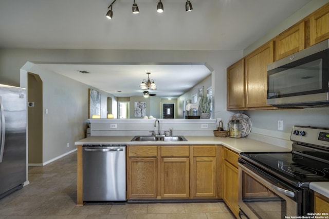 kitchen featuring kitchen peninsula, sink, light tile patterned flooring, and stainless steel appliances