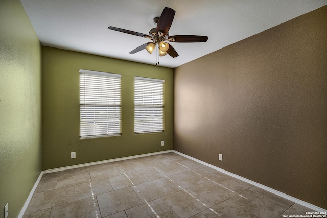 tiled empty room featuring ceiling fan