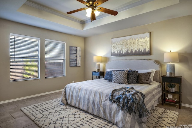 tiled bedroom featuring ceiling fan, a raised ceiling, and ornamental molding