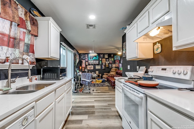 kitchen with white appliances, sink, ceiling fan, light wood-type flooring, and white cabinetry