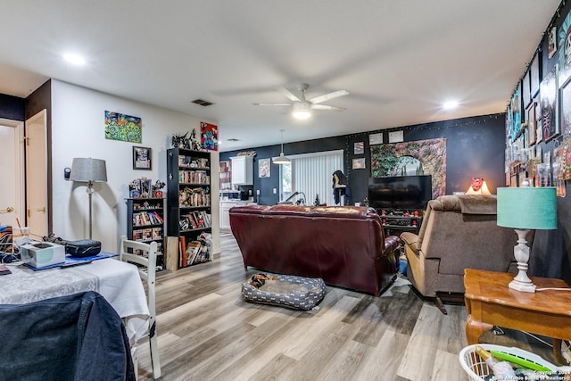 living room with light hardwood / wood-style flooring and ceiling fan