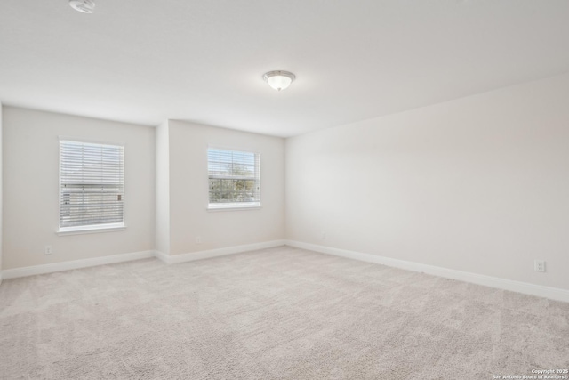 spare room featuring light colored carpet