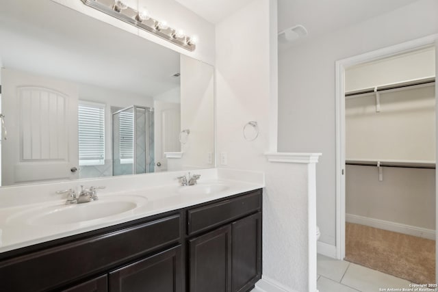 bathroom featuring tile patterned floors, an enclosed shower, and vanity