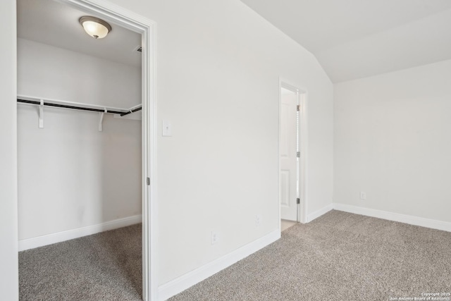 interior space featuring carpet floors, vaulted ceiling, and a closet