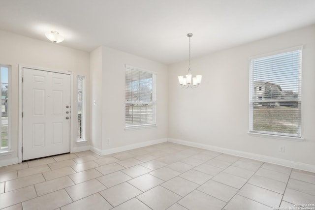 tiled foyer entrance with a wealth of natural light and a chandelier