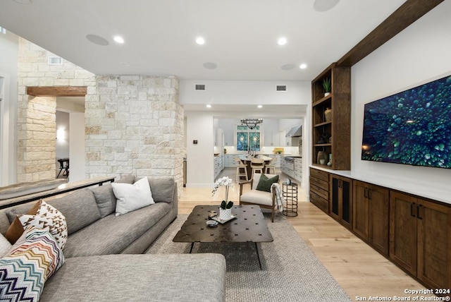 living room featuring built in shelves and light wood-type flooring