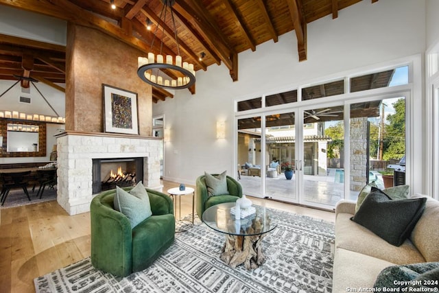 living room featuring wooden ceiling, high vaulted ceiling, hardwood / wood-style flooring, a fireplace, and beam ceiling