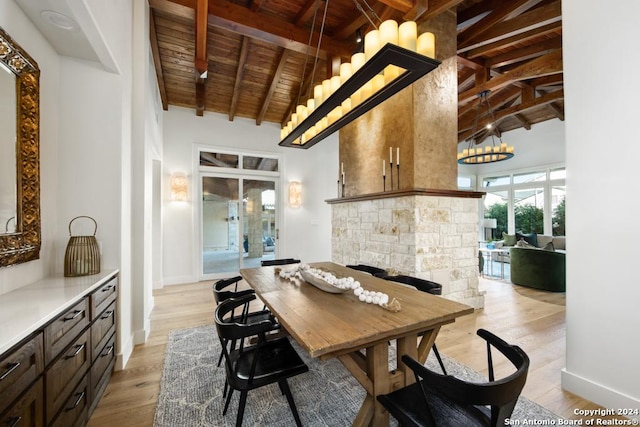 dining area with beam ceiling, light hardwood / wood-style flooring, high vaulted ceiling, and wood ceiling