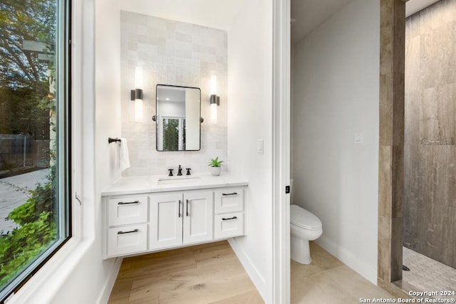 bathroom with walk in shower, backsplash, toilet, vanity, and hardwood / wood-style flooring