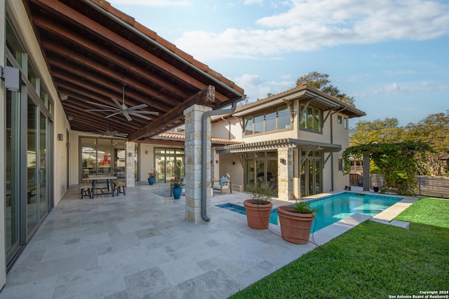 view of pool with ceiling fan, a patio area, and a lawn