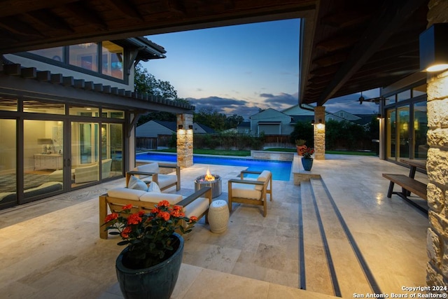 pool at dusk with an outdoor living space, a patio, and a hot tub