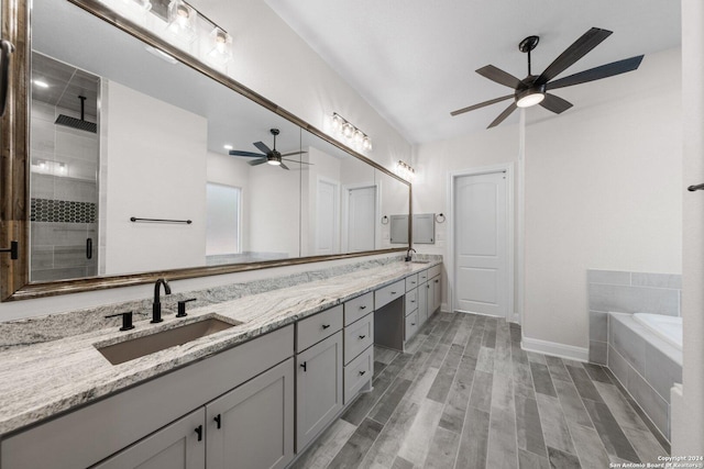 bathroom with shower with separate bathtub, vanity, ceiling fan, and wood-type flooring