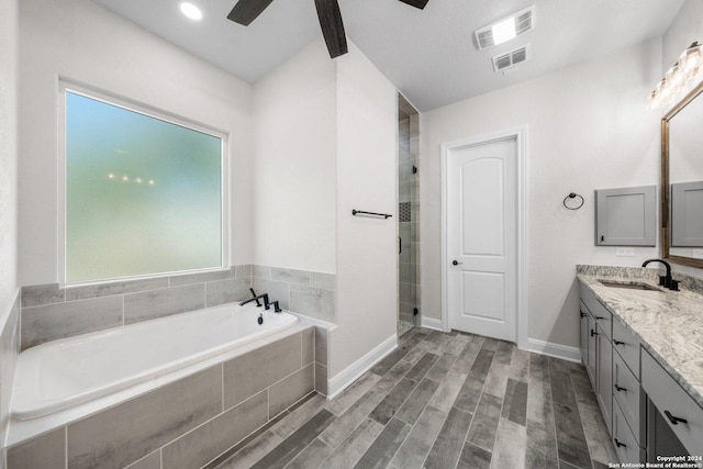 bathroom featuring plus walk in shower, wood-type flooring, vanity, and ceiling fan