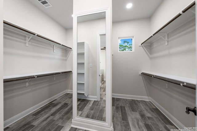 spacious closet featuring dark hardwood / wood-style floors