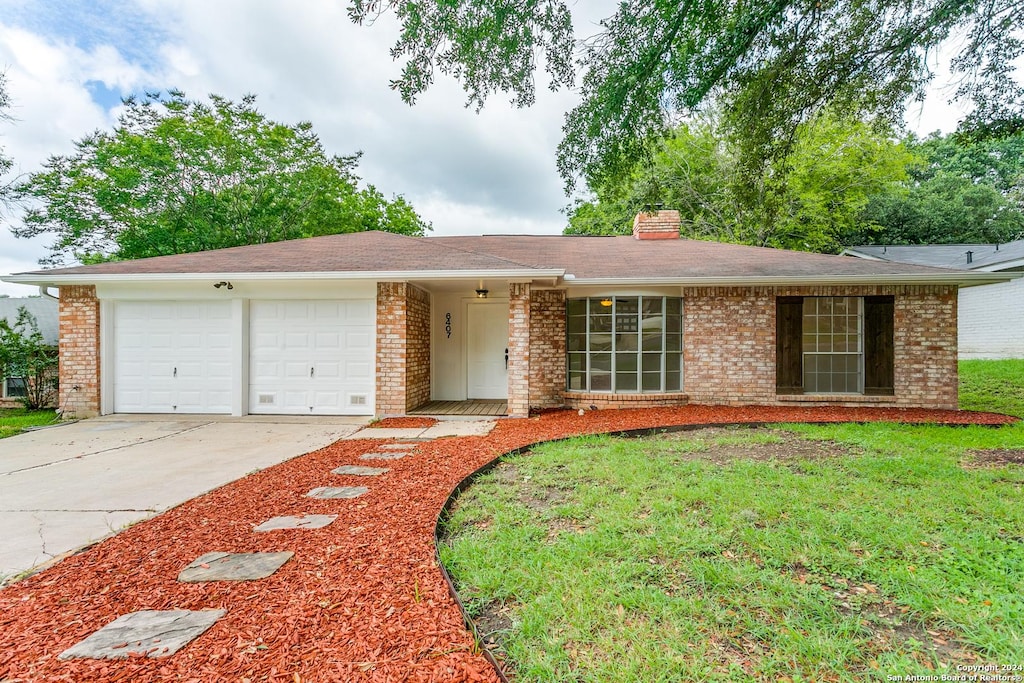 single story home with a garage and a front lawn