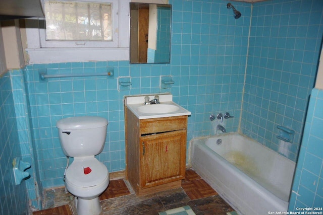 full bathroom featuring vanity, toilet, tile walls, and tiled shower / bath