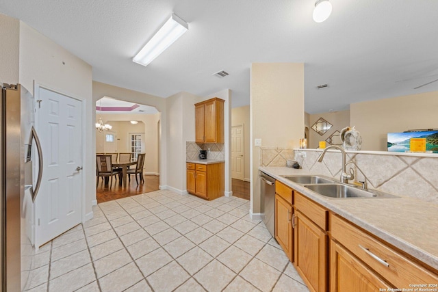 kitchen with backsplash, sink, light tile patterned flooring, and stainless steel appliances