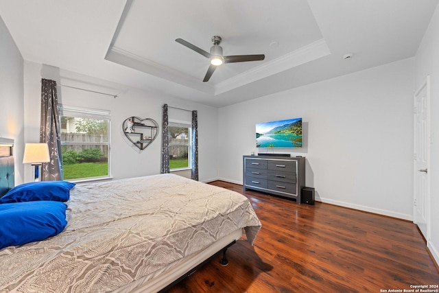 bedroom with a raised ceiling, ceiling fan, dark hardwood / wood-style flooring, and ornamental molding