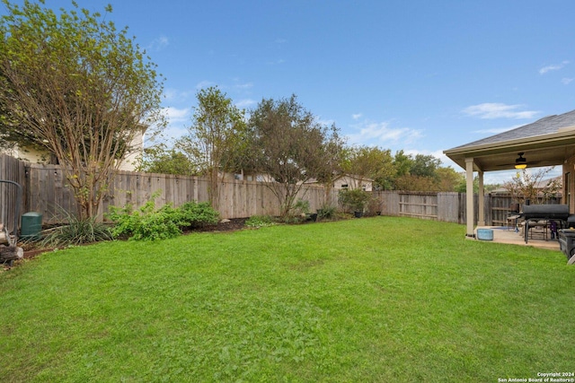 view of yard with ceiling fan and a patio